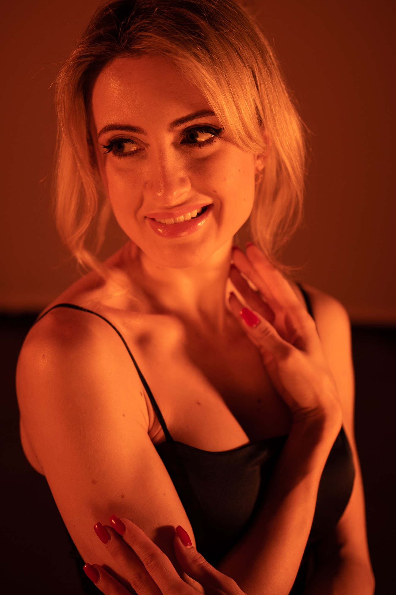 Shanelle smiling in a close black-dress portrait