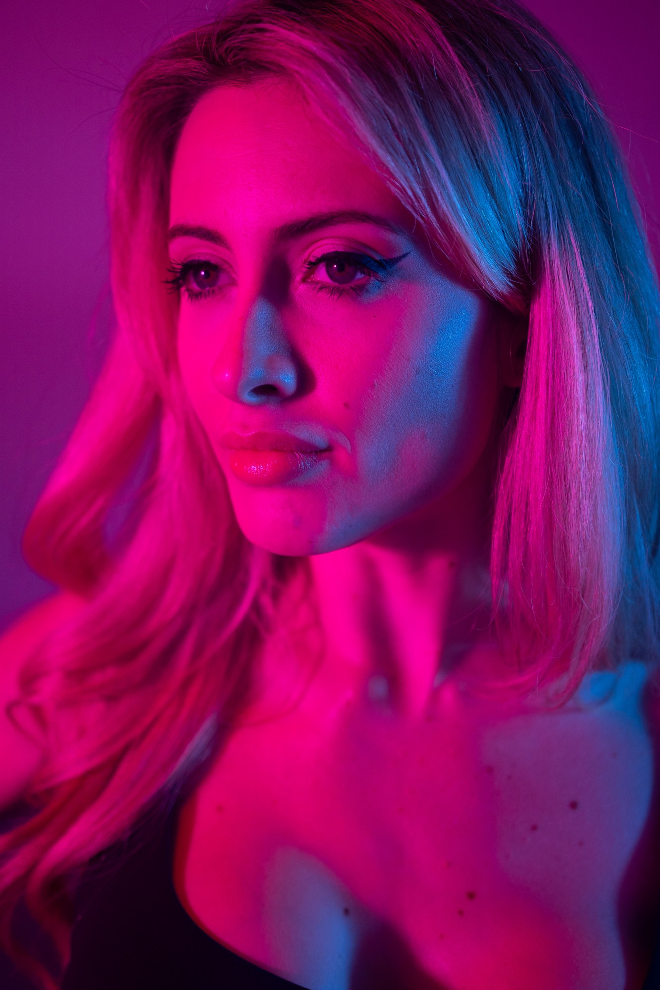 Shanelle looking aside under blue and magenta lights