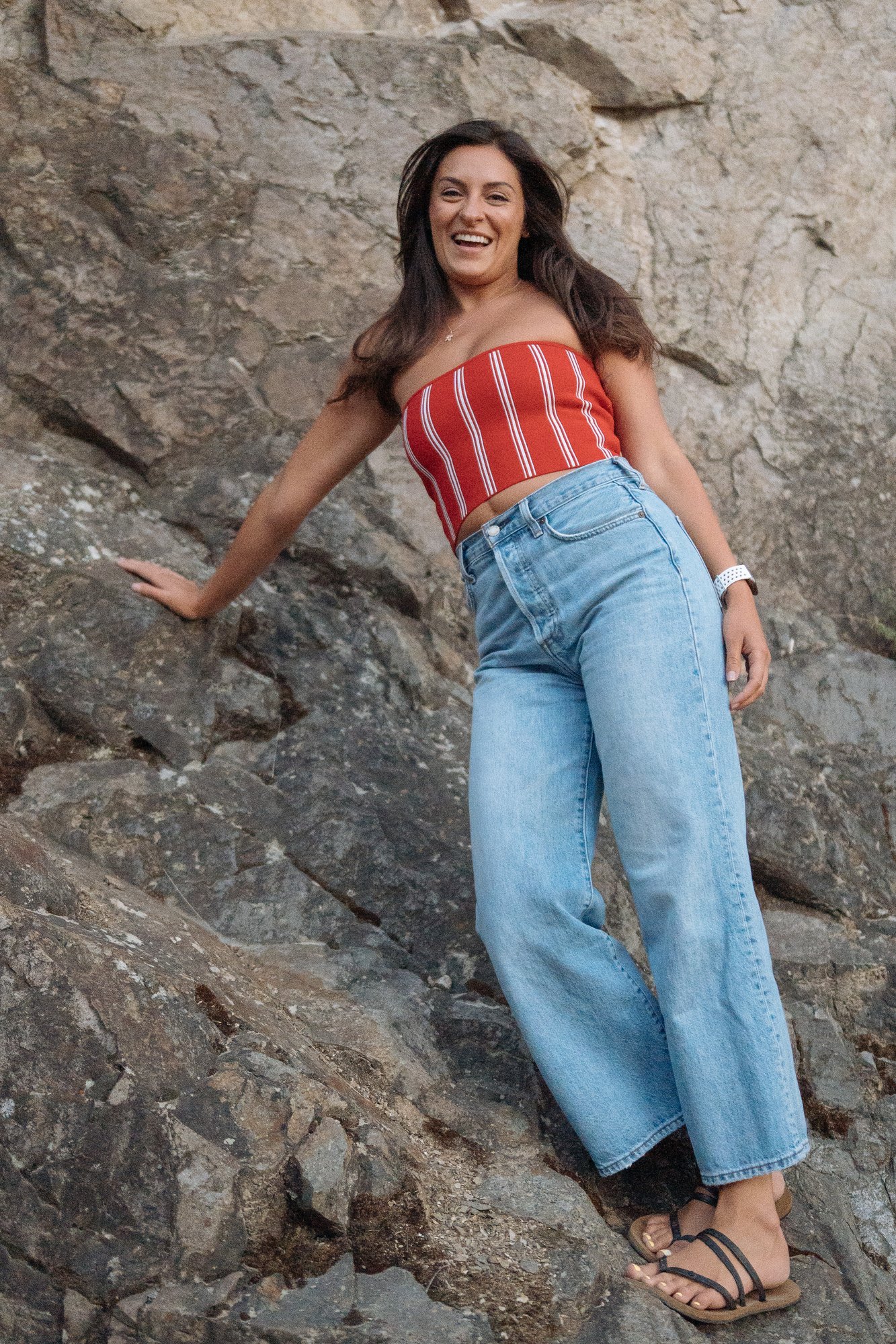 Shatille — red striped top and jeans against the cliff