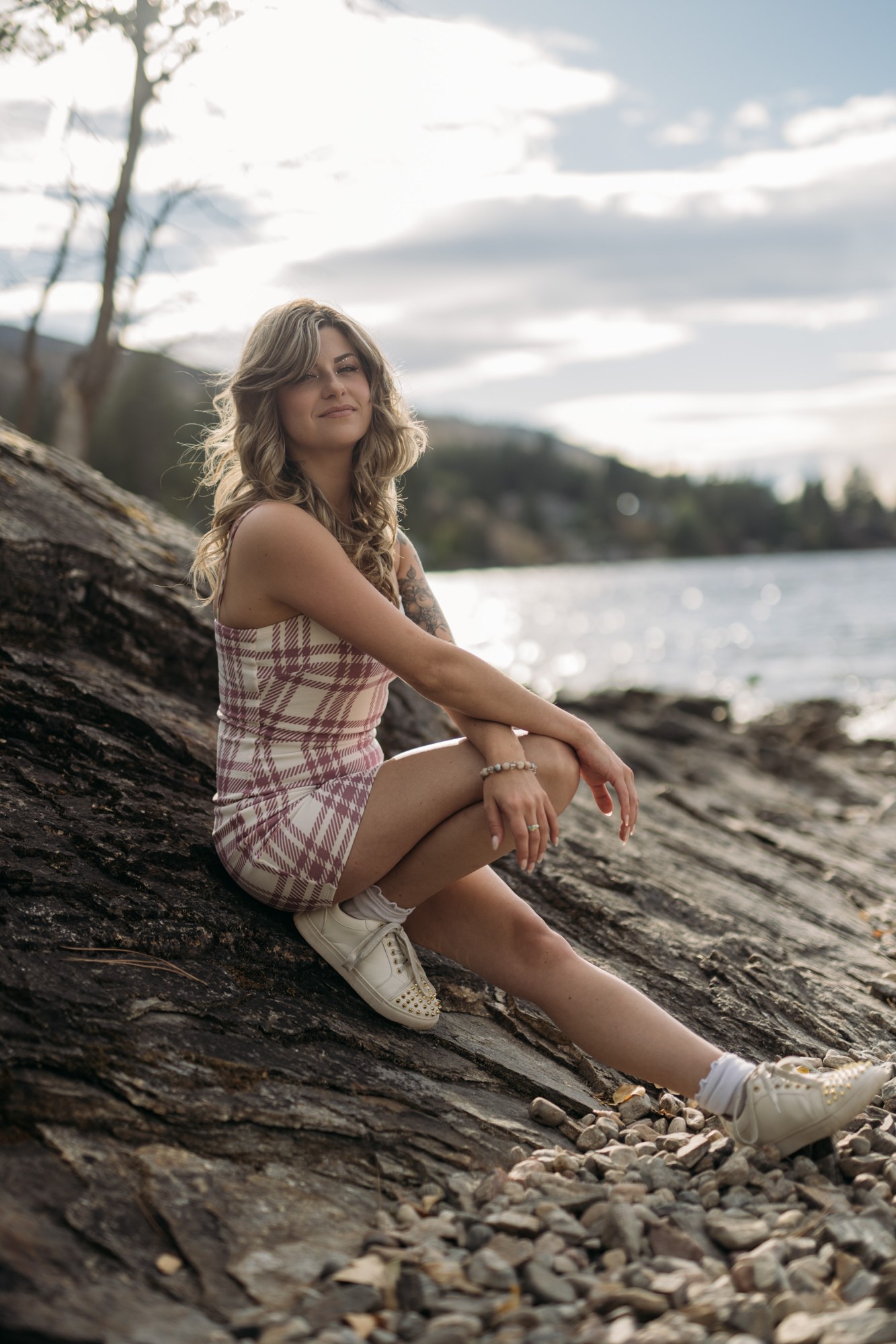 Sophia at Bertram Creek Park: Seated figure at the backlit shoreline.