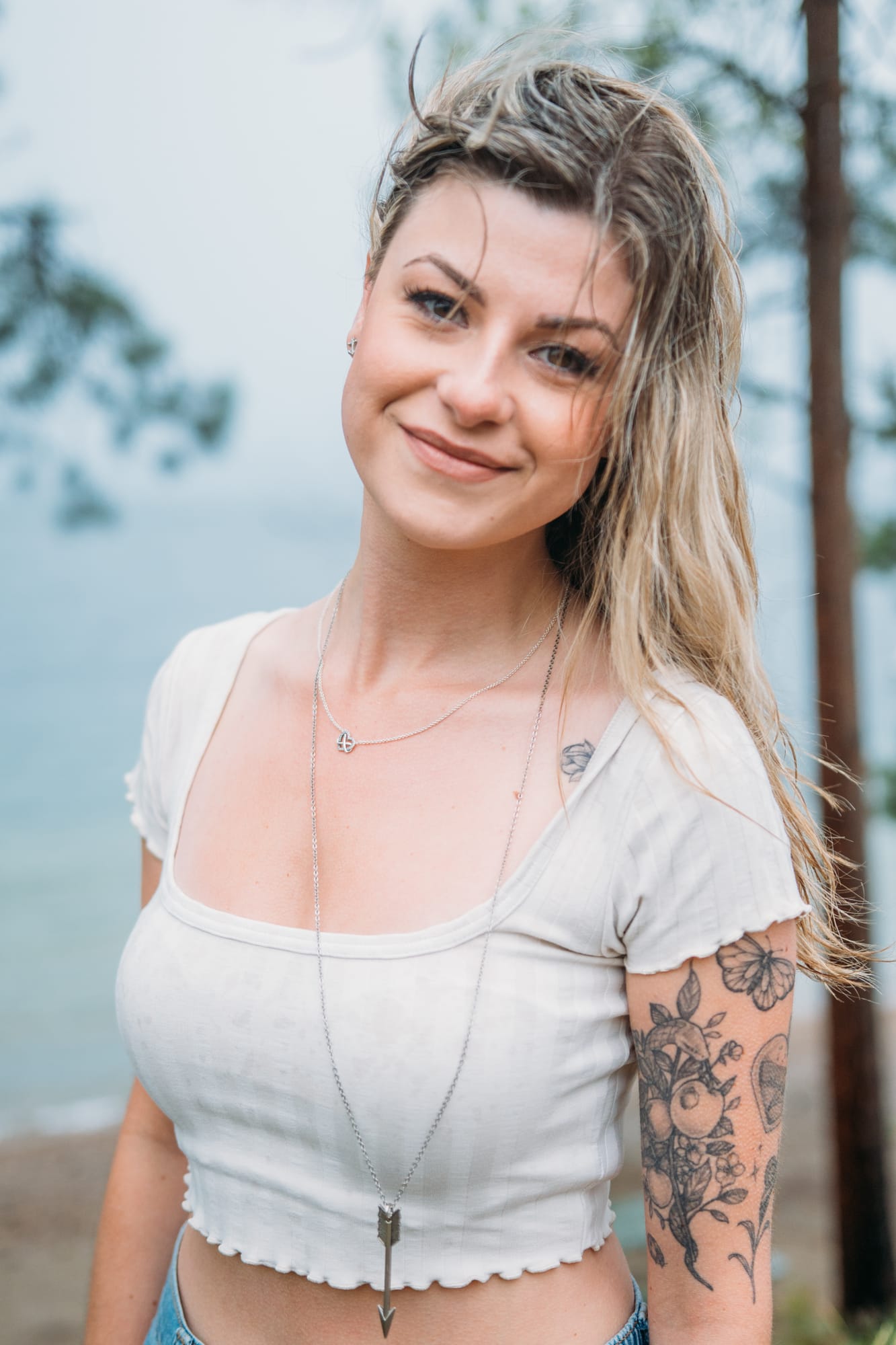 Sophia by the Lake portraits story frame 14: A multi-outfit Okanagan location session with water, trees, shoreline, denim and red swimwear woven into a summer portrait story.