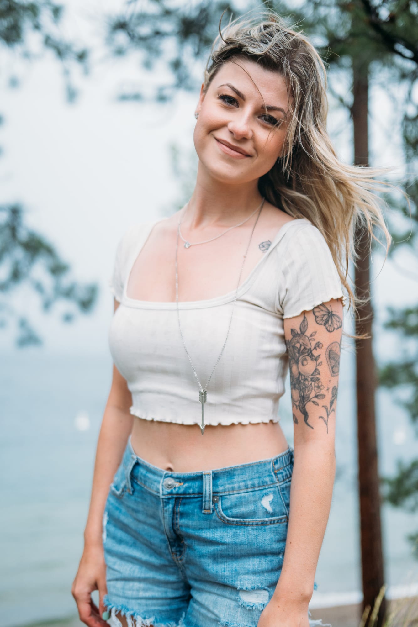 Sophia by the Lake portraits story frame 15: A multi-outfit Okanagan location session with water, trees, shoreline, denim and red swimwear woven into a summer portrait story.