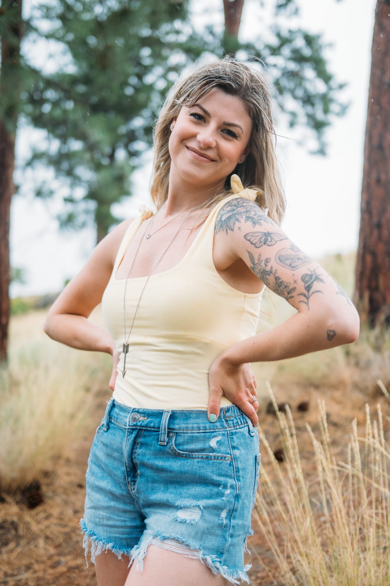 Sophia by the Lake portraits story frame 17: A multi-outfit Okanagan location session with water, trees, shoreline, denim and red swimwear woven into a summer portrait story.