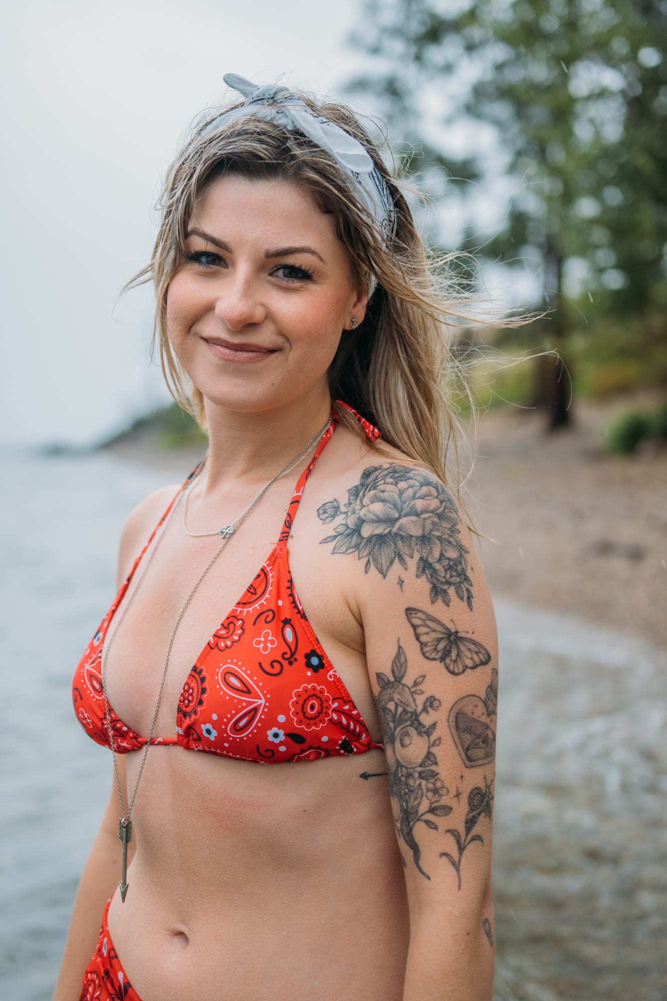 Sophia by the Lake portraits story frame 33: A multi-outfit Okanagan location session with water, trees, shoreline, denim and red swimwear woven into a summer portrait story.