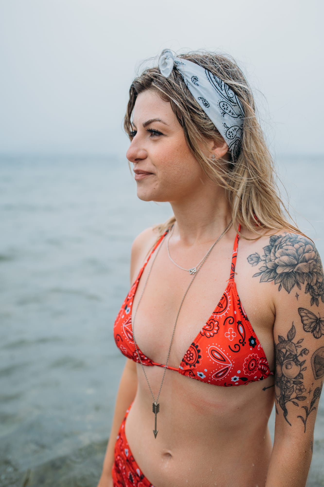 Sophia by the Lake portraits story frame 34: A multi-outfit Okanagan location session with water, trees, shoreline, denim and red swimwear woven into a summer portrait story.