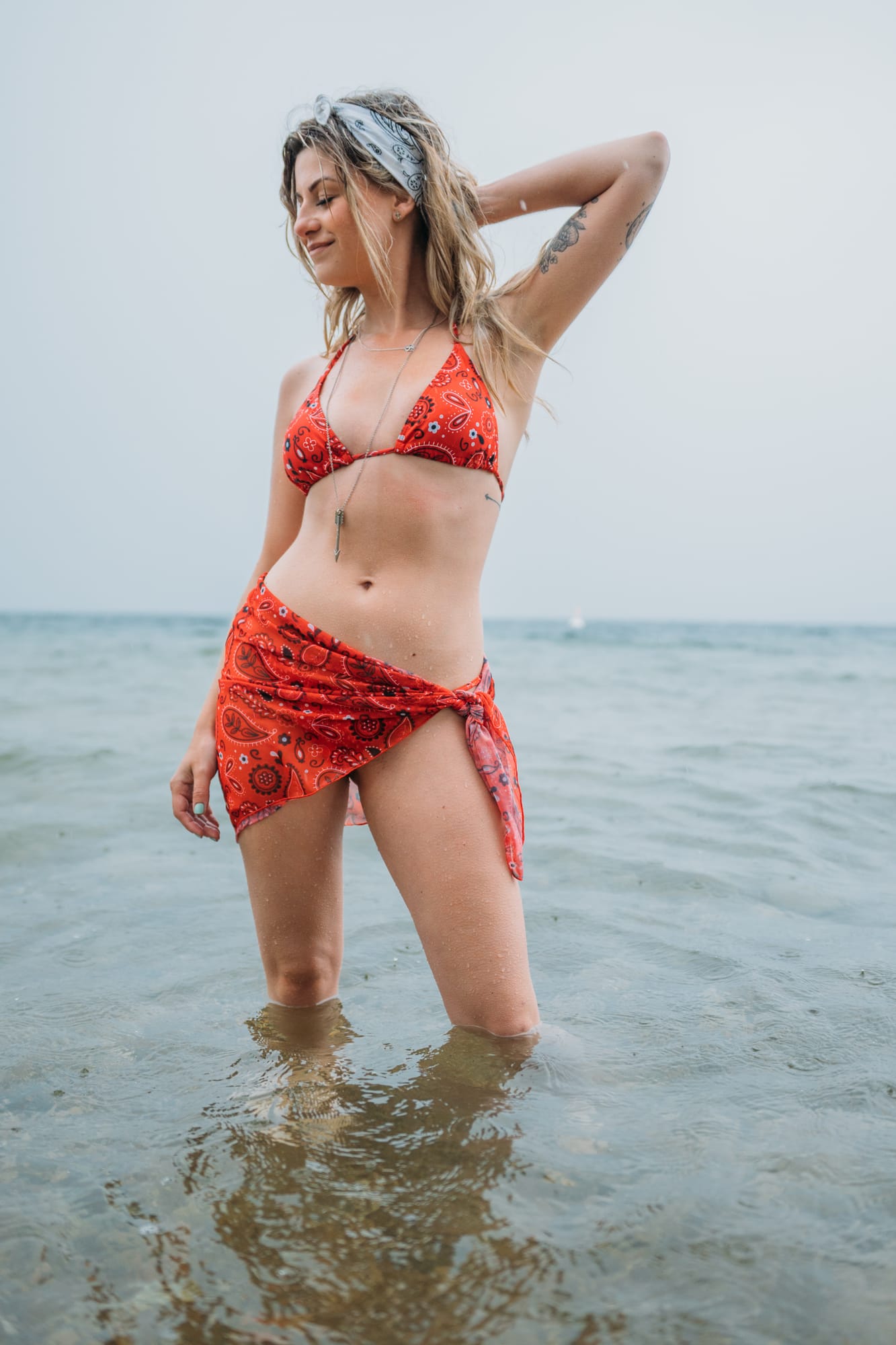 Sophia by the Lake portraits story frame 35: A multi-outfit Okanagan location session with water, trees, shoreline, denim and red swimwear woven into a summer portrait story.