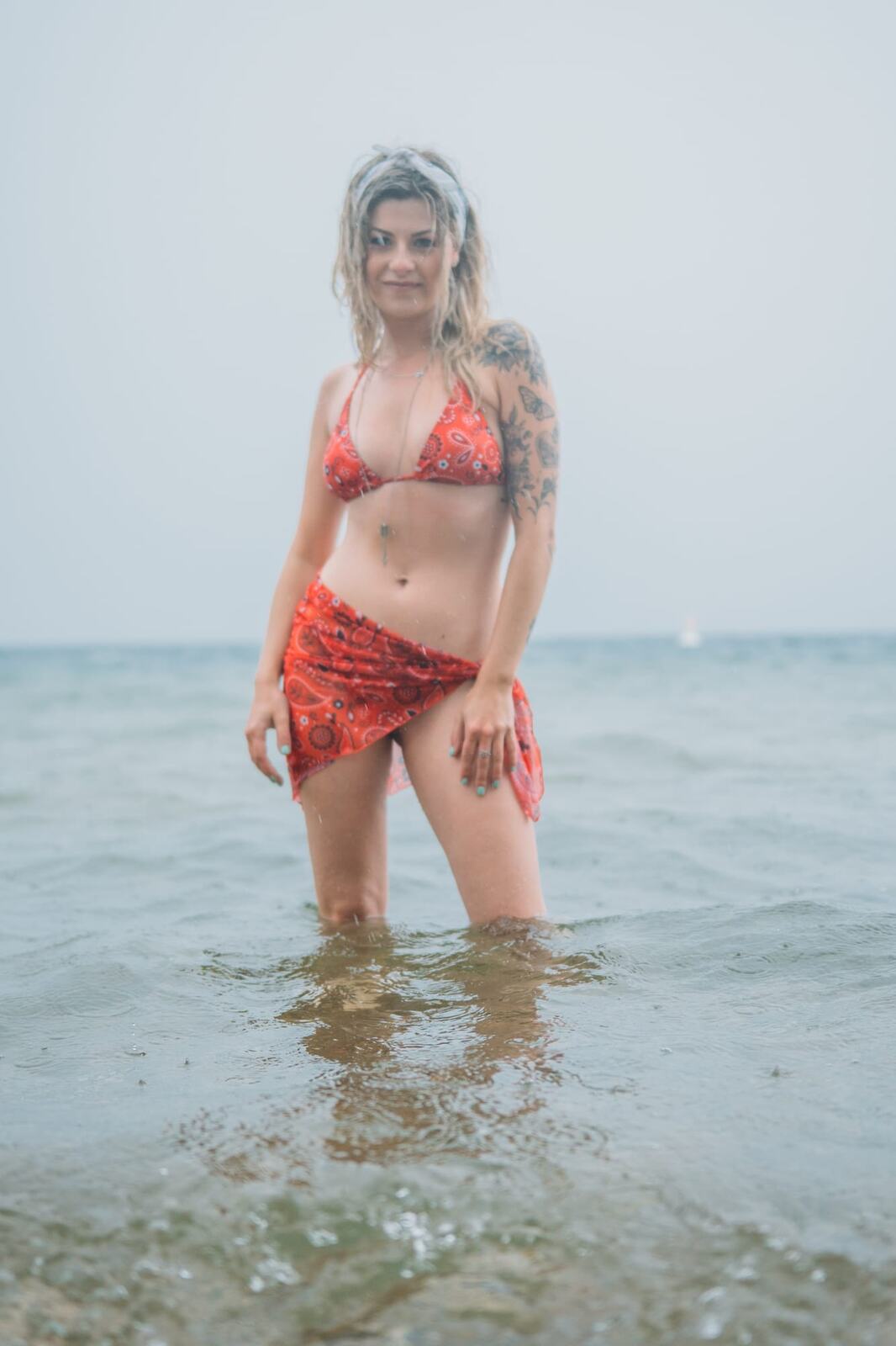 Sophia by the Lake portraits story frame 30: A multi-outfit Okanagan location session with water, trees, shoreline, denim and red swimwear woven into a summer portrait story.