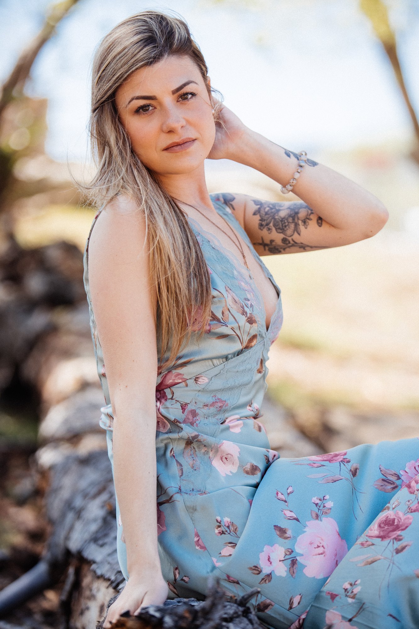 Sophia — seated portrait on a fallen tree beside the lake
