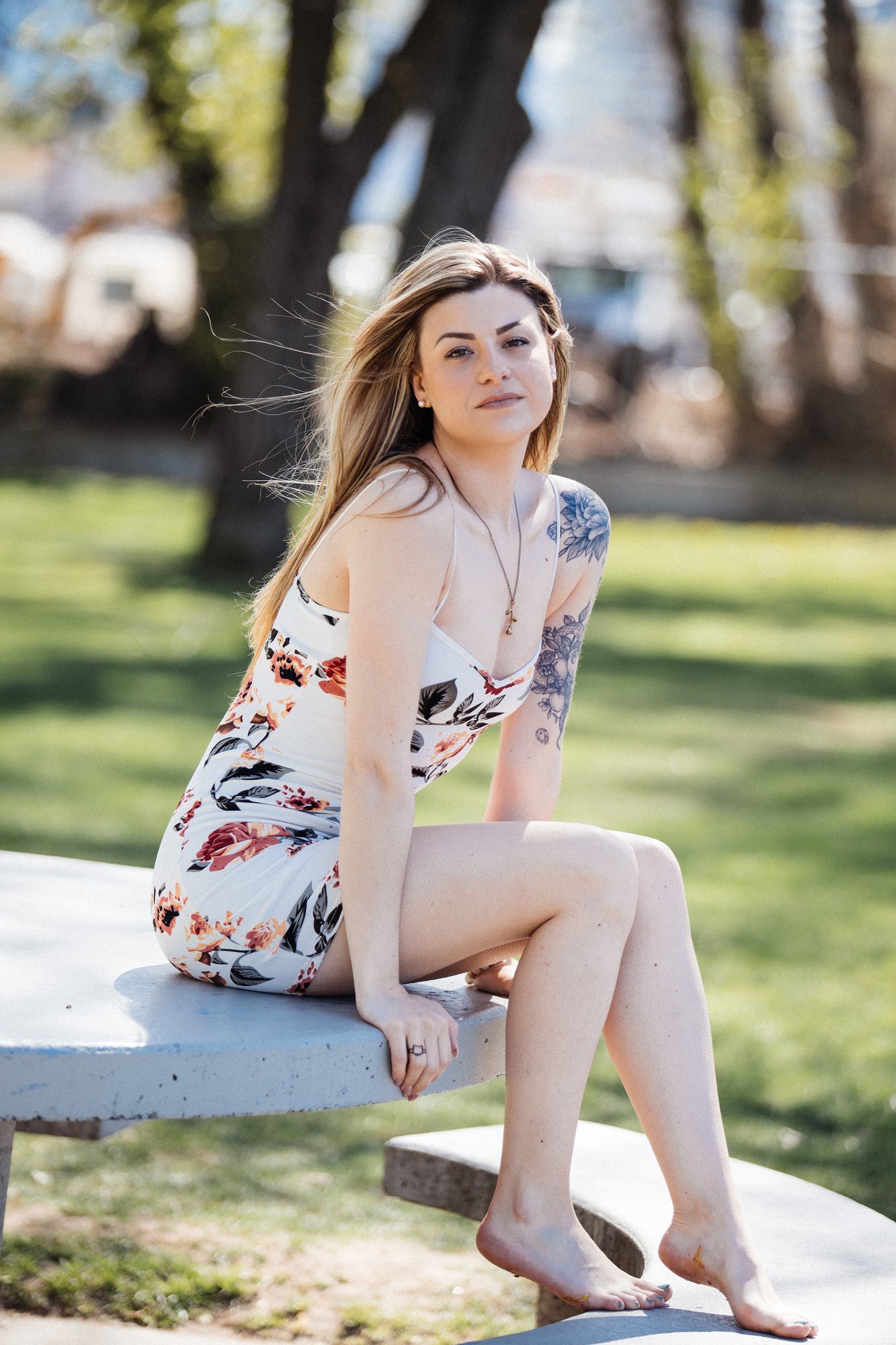 Sophia — sitting on a park table in a short floral dress