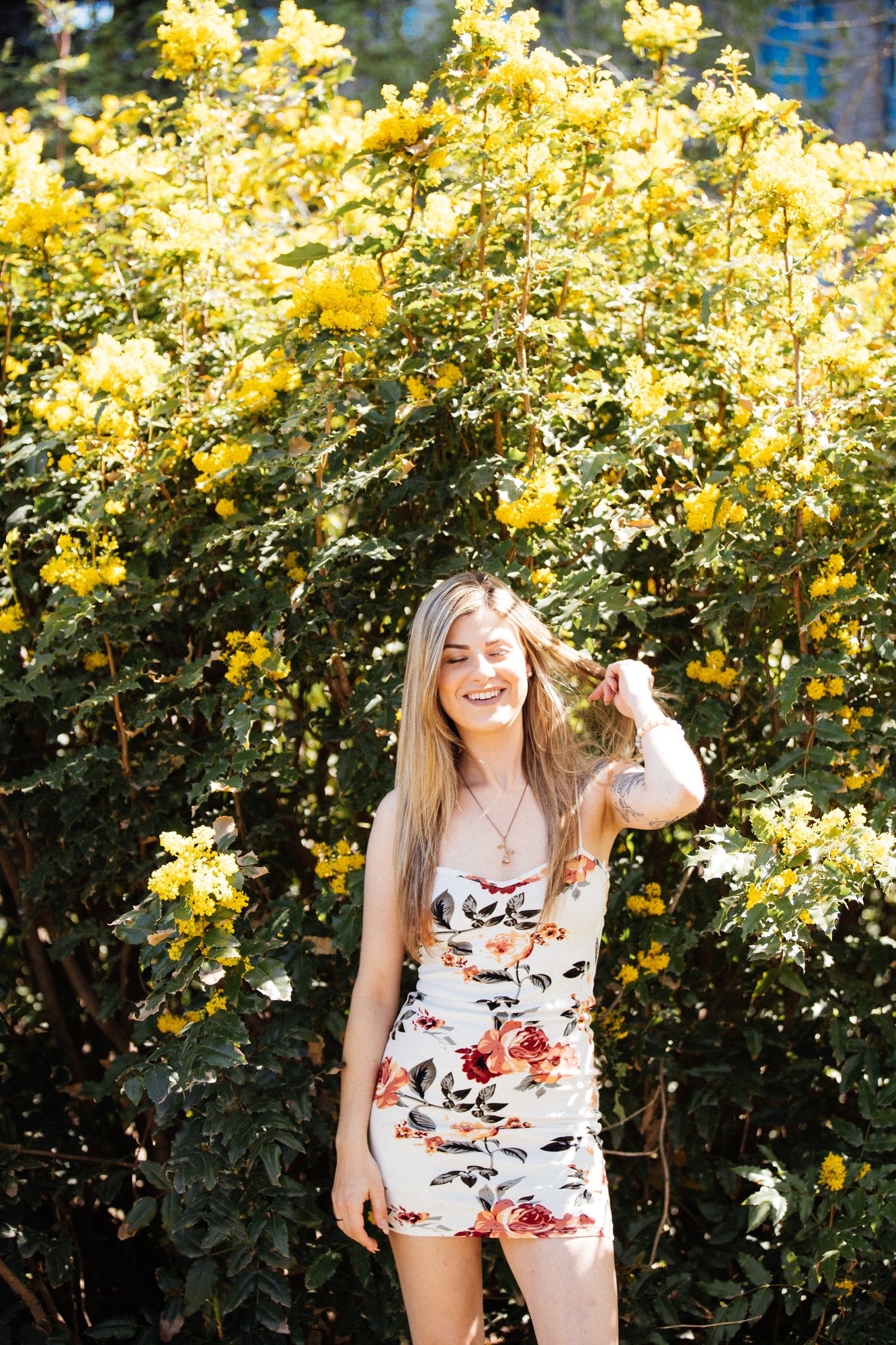 Sophia — standing beside the yellow flowers with a hand in her hair