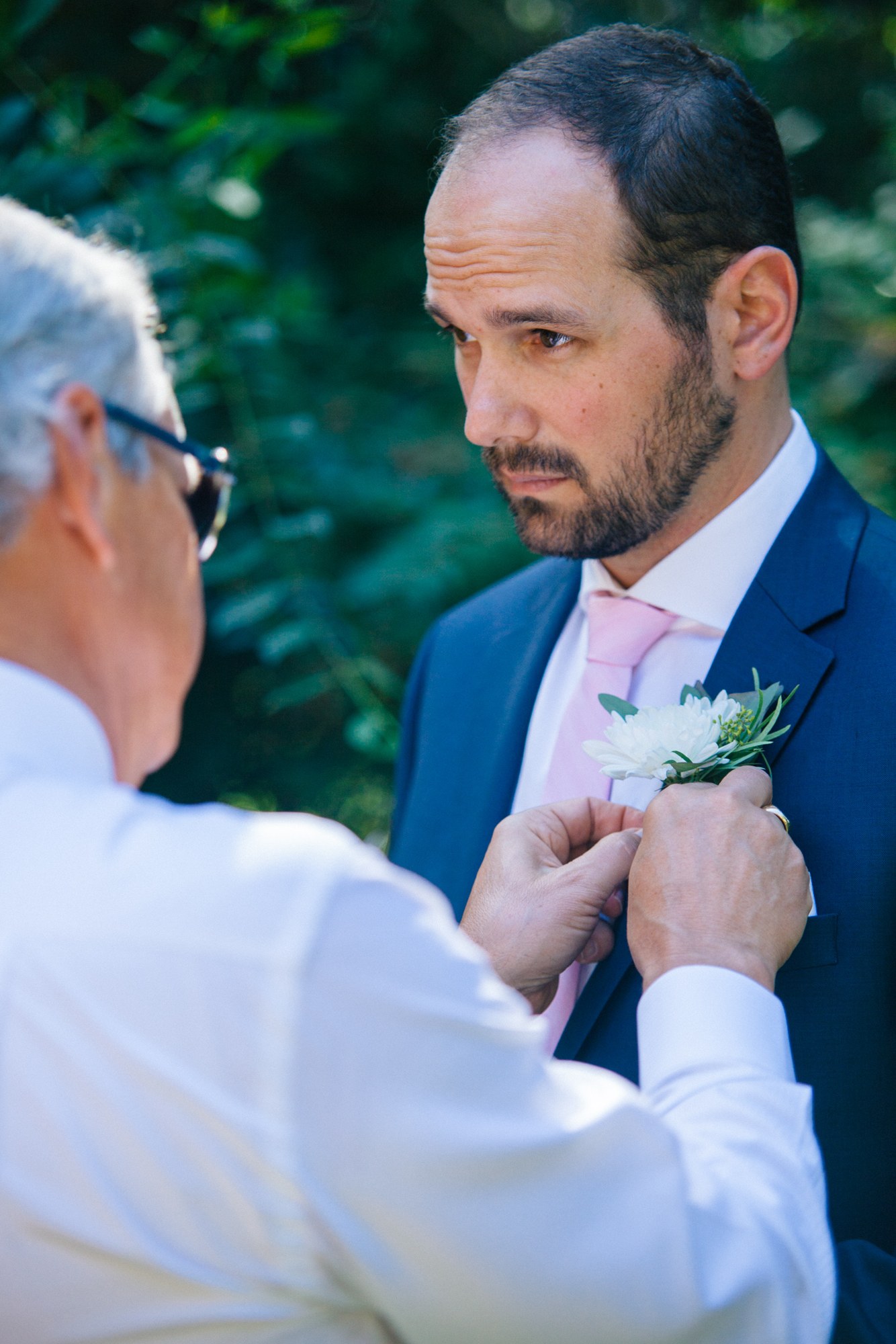 Steph & Taylor: A buttonhole being pinned to the groom’s jacket.