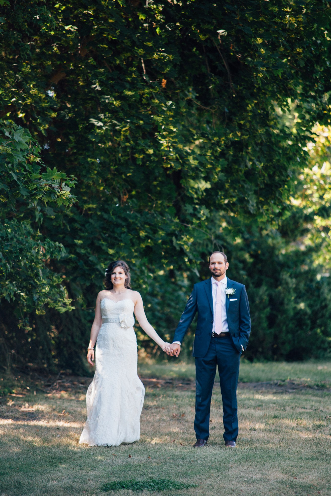 Steph & Taylor: The couple holding hands beneath the trees.