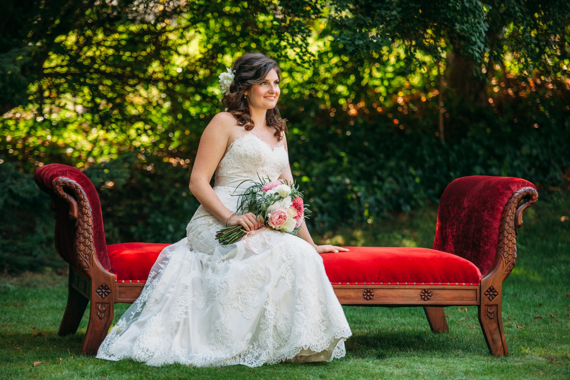 Steph & Taylor: Full portrait of the bride on the red sofa.