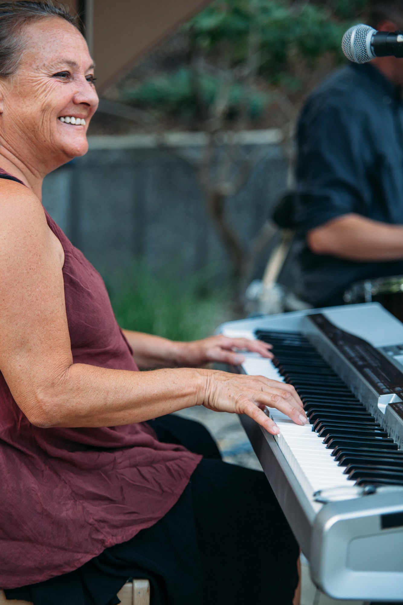 Steph & Taylor: A smiling musician playing the keyboard.