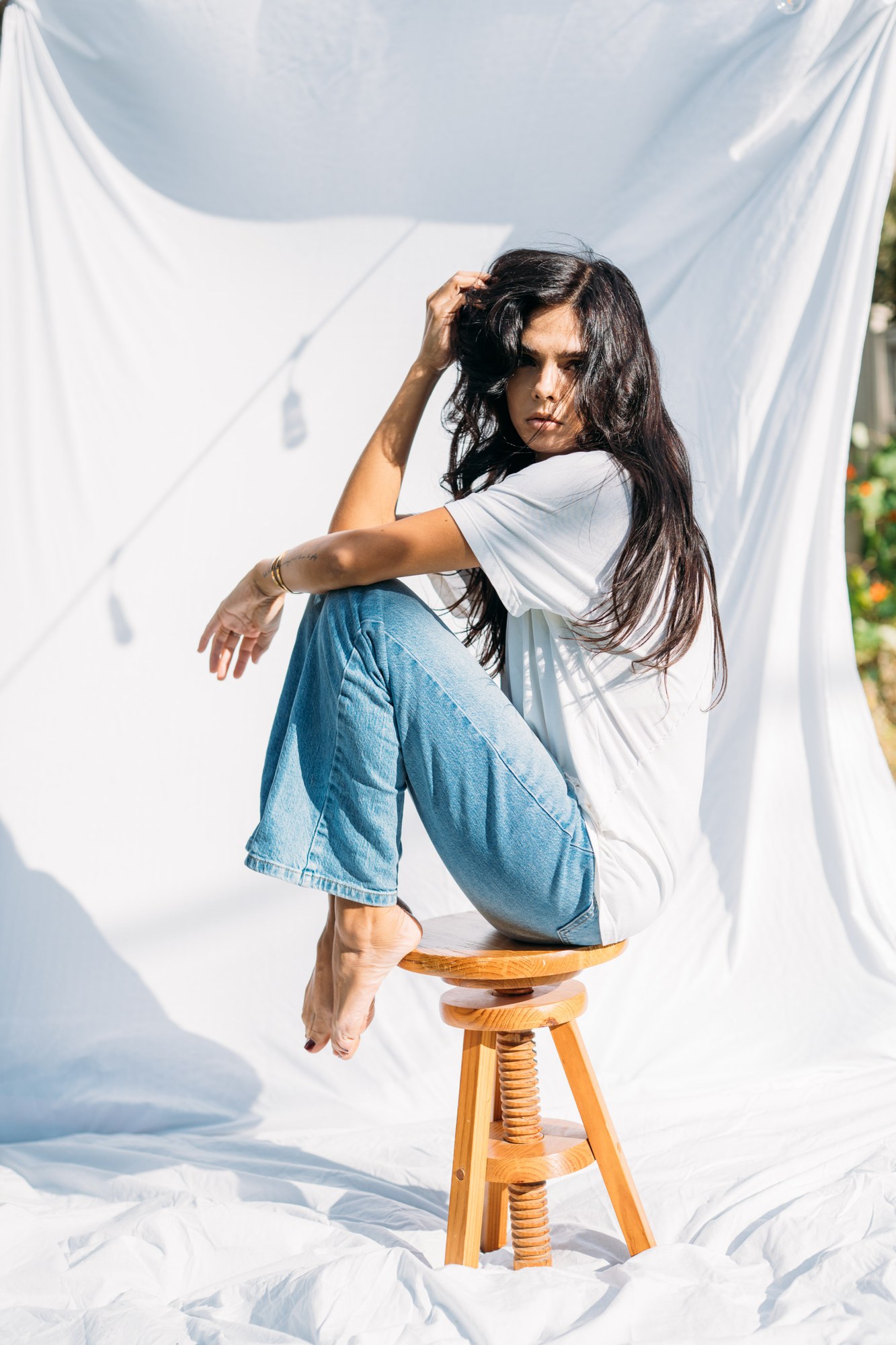 Sunny in Sunlight: Full seated figure on the wooden stool.