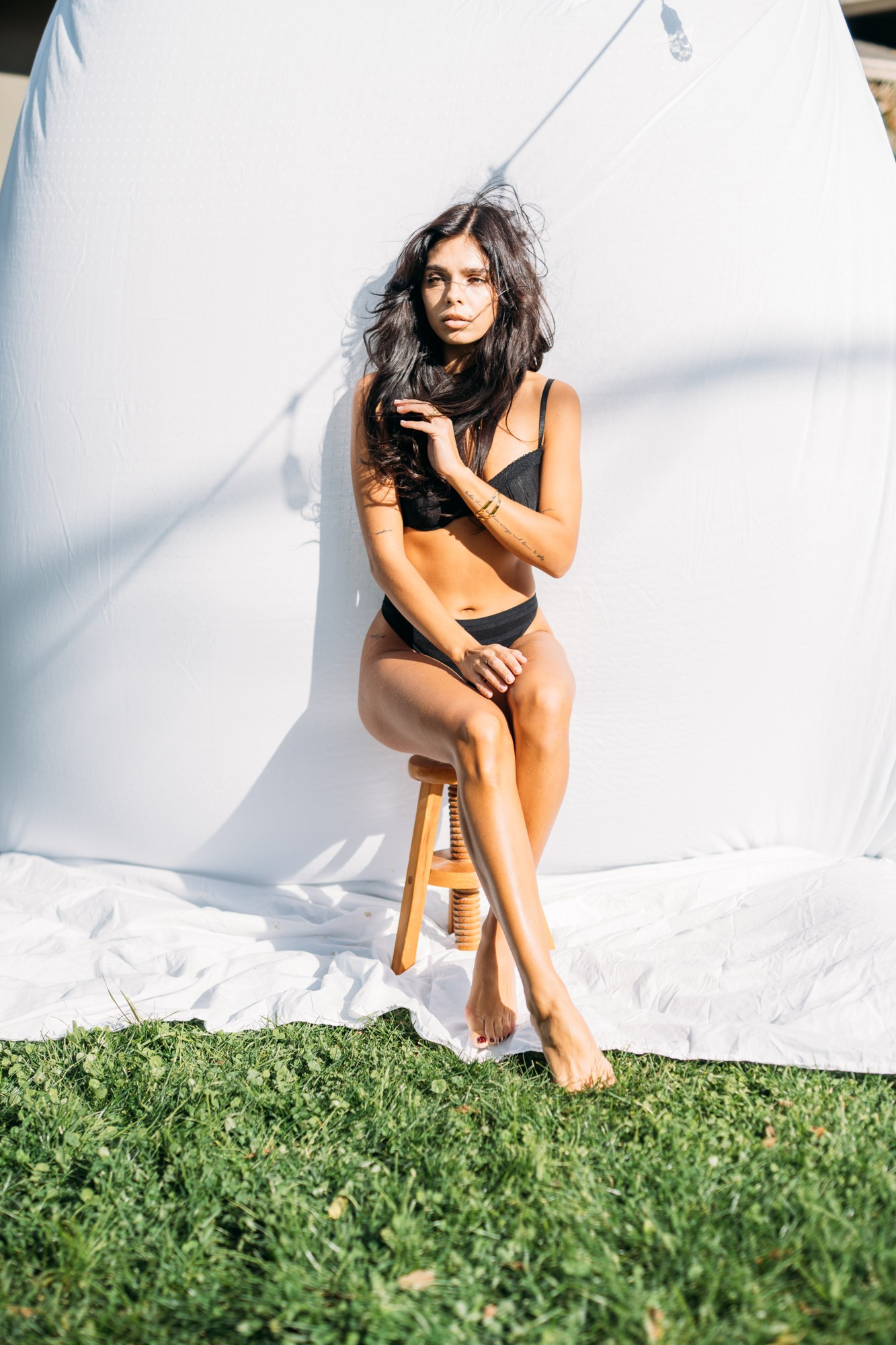 Sunny in Sunlight: Folded legs on the stool in the black look.