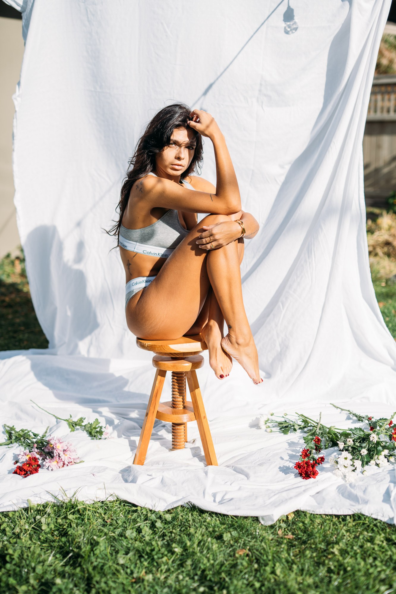 Sunny in Sunlight: Curled knees on the stool in the pale look.