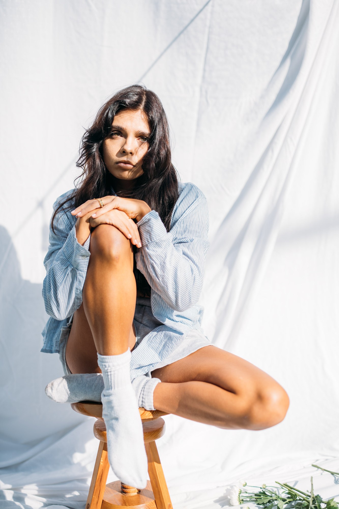 Sunny in Sunlight: Full seated denim-shirt pose.