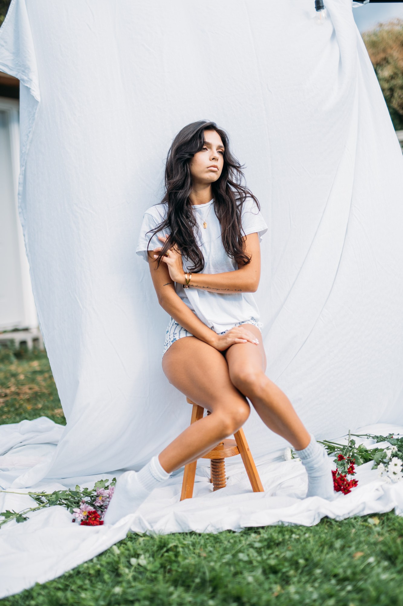 Sunny in Sunlight: Seated white tee and striped shorts.