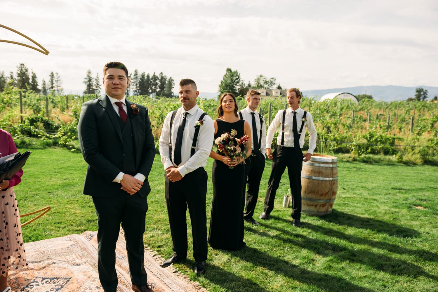 Taryn and Kai weddings story frame 12: An Okanagan vineyard wedding with ceremony, veil, guests, family, makeup by Guisachan Esthetics, and laughter woven through the altar moments..