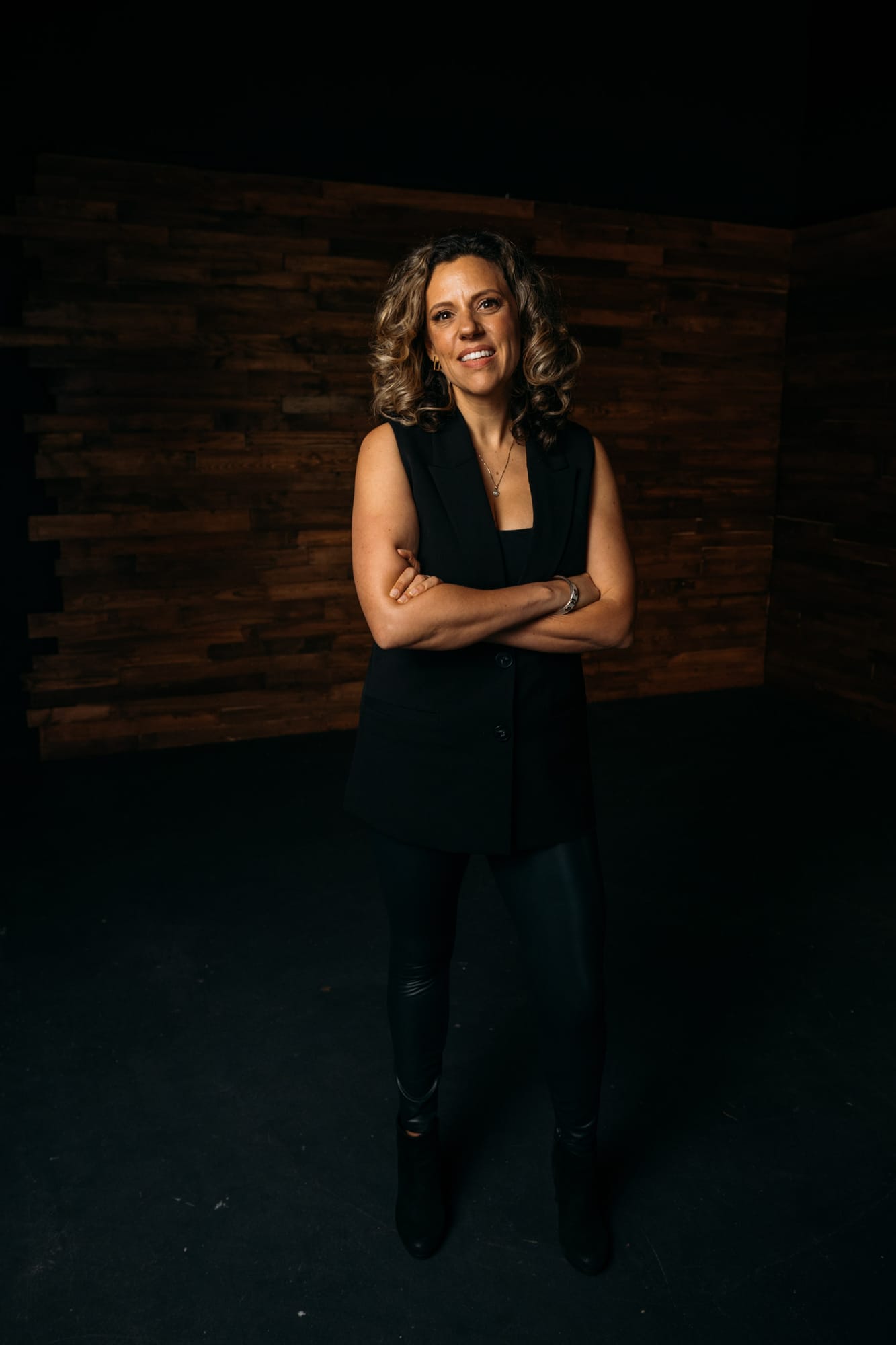 Trisha Miltimore corporate story frame 6: Personal-brand portraits for Trisha Miltimore in Kelowna, moving from clean business profile images into darker wood-wall portraits with black wardrobe and confident brand range..