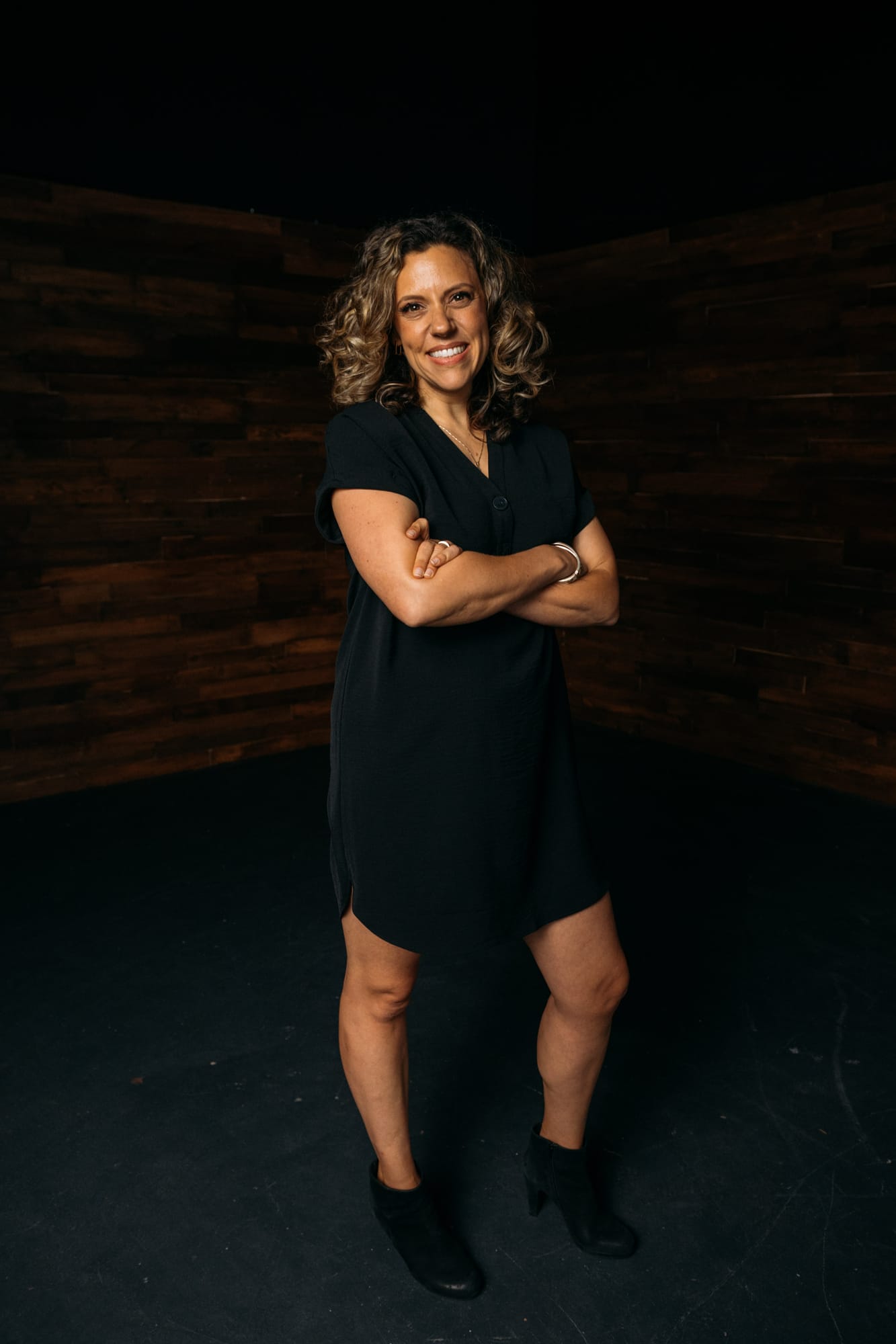 Trisha Miltimore corporate story frame 12: Personal-brand portraits for Trisha Miltimore in Kelowna, moving from clean business profile images into darker wood-wall portraits with black wardrobe and confident brand range..