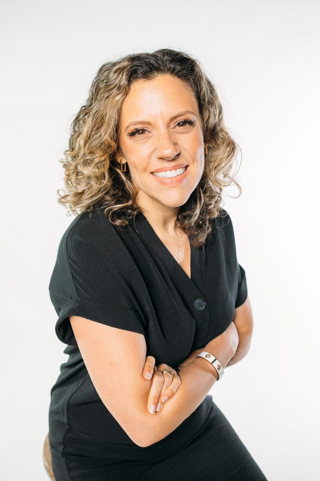 Trisha Miltimore corporate story frame 16: Personal-brand portraits for Trisha Miltimore in Kelowna, moving from clean business profile images into darker wood-wall portraits with black wardrobe and confident brand range..